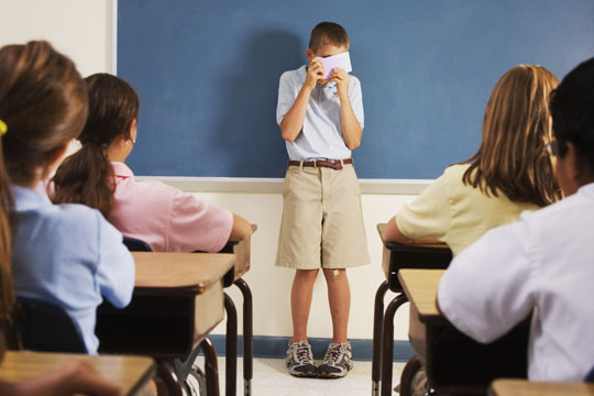 Shy Student Hiding Behind Note Cards During Class Presentati